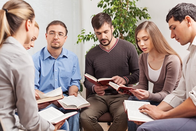 Groupe de personnes lisant le livre de la Bible ensemble