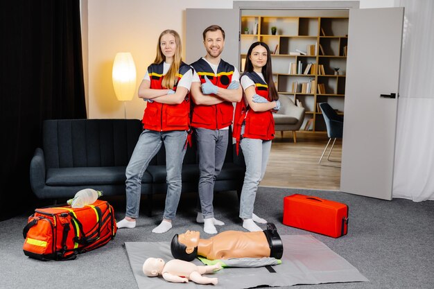 Groupe de personnes avec un mannequin de cpr regardant la caméra et souriant après le cours de formation aux premiers secours