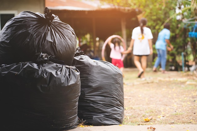 Photo un groupe de personnes marche devant un sac poubelle.