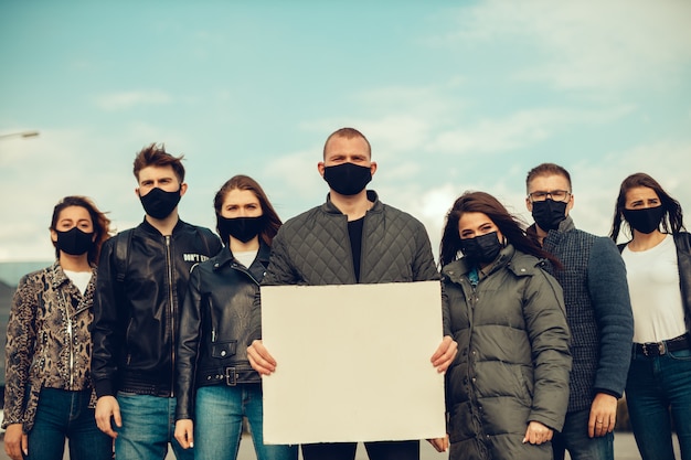 Un groupe de personnes avec masque et affiches pour protester La protestation de la population contre le coronavirus et contre l'introduction de la quarantaine