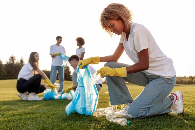 un groupe de personnes multiraciales en gants et avec des sacs à ordures enlèvent le plastique et les ordures