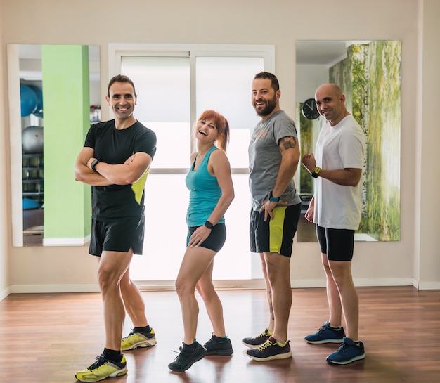 Groupe de personnes posant et plaisantant dans une salle de sport