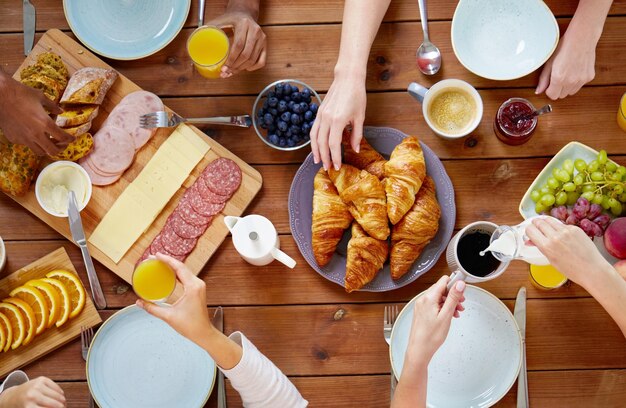 Photo groupe de personnes prenant le petit déjeuner et s'asseyant à table