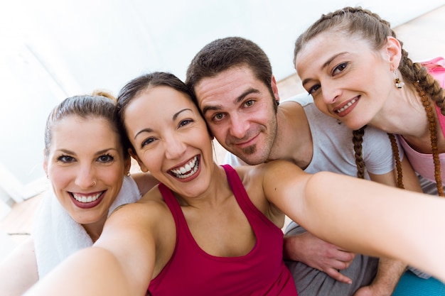 Groupe de personnes prenant un selfie après la session de yoga.