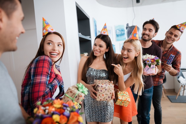 Groupe de personnes prépare une surprise pour fille d'anniversaire.