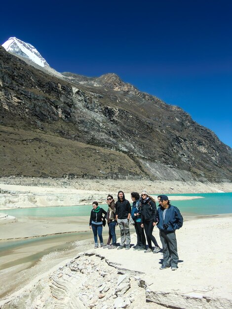 Groupe de personnes près d'un lac dans les Andes péruviennes