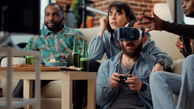 Groupe de personnes s'amusant avec des jeux vidéo en ligne sur une console de jeu, jouant au défi avec un casque de réalité virtuelle. Utiliser des lunettes vr pour jouer à la compétition à la télévision. Prise de vue à main levée.