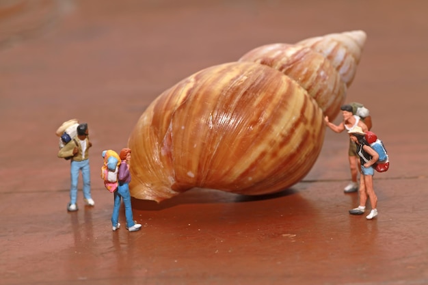 Un groupe de personnes se tient à côté d'un escargot géant.