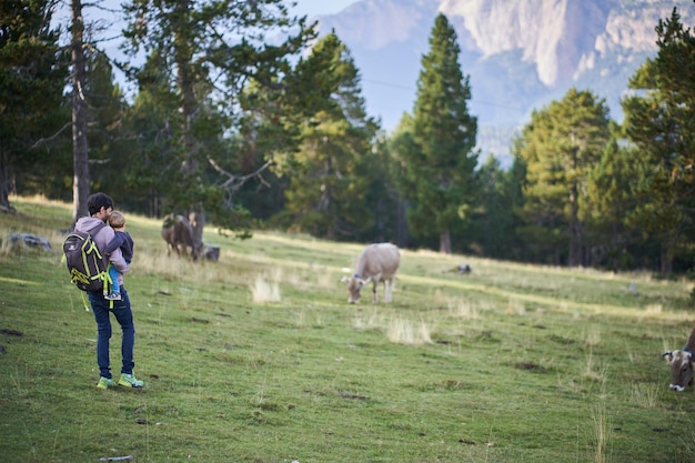 Un groupe de personnes se tient dans un champ avec des vaches en arrière-plan.