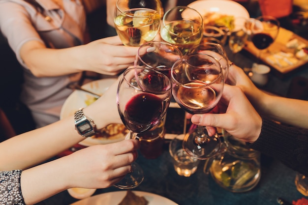 groupe de personnes tinter les verres avec du vin ou du champagne