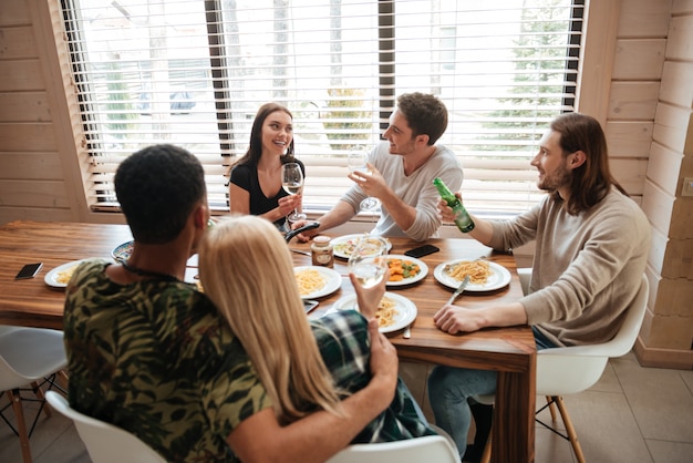 Groupe de personnes en train de dîner et de parler dans la cuisine