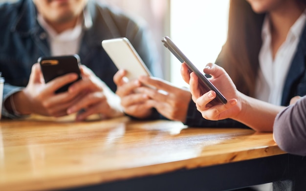 Groupe de personnes utilisant et regardant un téléphone portable assis ensemble