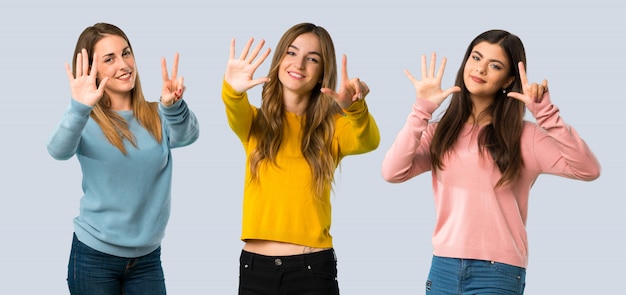 Groupe de personnes avec des vêtements colorés comptant sept avec les doigts sur fond coloré