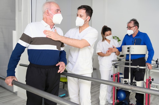 Groupe de physiothérapeutes travaillant dans un centre de réadaptation, aidant les patients.