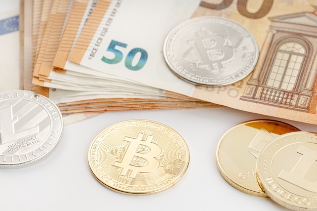 Groupe de pièces de monnaie crypto et billets en euros. L'argent blockchain contre le concept de monnaie fiduciaire
