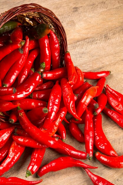 Groupe de piments rouges frais sur une table en bois. Poivrons frais.