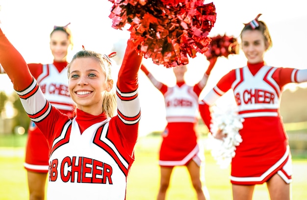 Groupe de pom-pom girls féminines se produisant à l'extérieur sur le campus universitaire