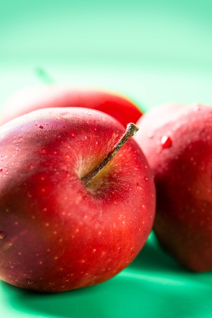 Groupe de pommes fraîches rouges sur fond vert