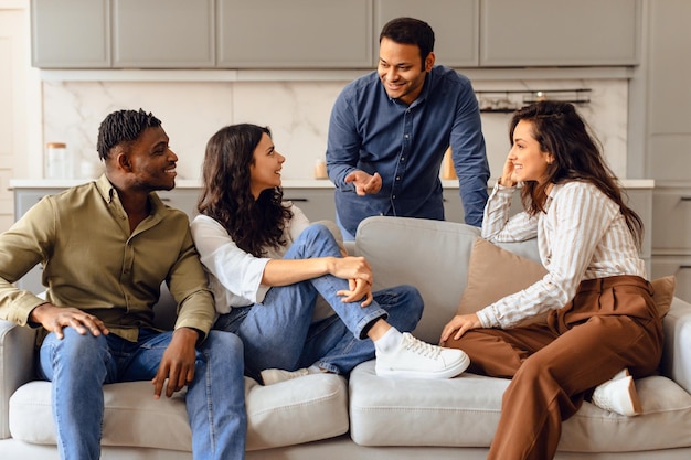 Un groupe de quatre étudiants divers parlent assis dans le salon