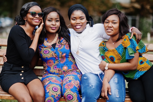 Photo groupe de quatre femmes assises sur un banc en plein air et des câlins