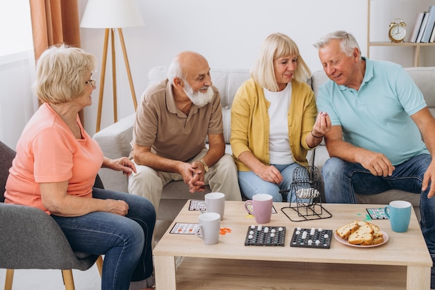 Photo un groupe de quatre personnes âgées joyeuses jouant au bingo dans une maison de retraite