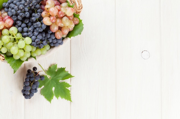 Groupe de raisins rouges pourpres et blancs dans le panier