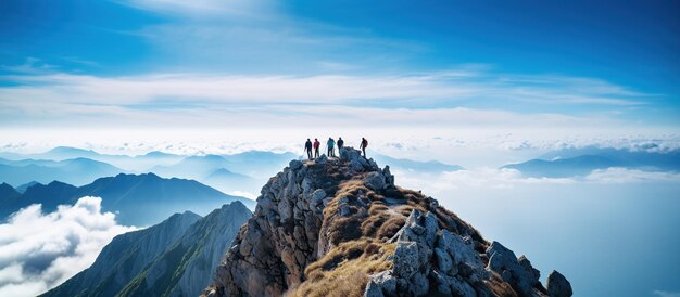 Un groupe de randonneurs au sommet de la montagne contre le coucher du soleil dans le ciel bleu par une journée ensoleillée