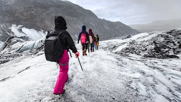 Groupe de randonneurs marcher sur le glacier pendant la neige sur Solheimajokull