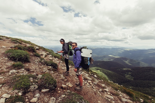 Un groupe de randonneurs avec des sacs à dos marche le long d'un sentier vers une crête de montagne