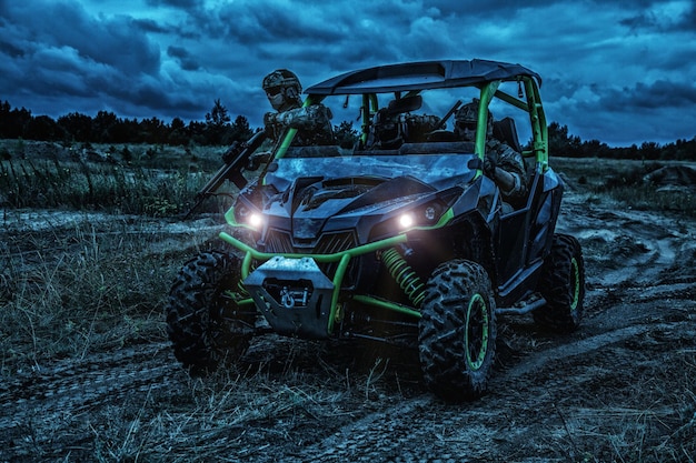 Groupe de réaction rapide des commandos, équipe mobile des forces d'opérations spéciales à bord d'un véhicule d'attaque rapide ou d'un sandrail militaire pendant les patrouilles nocturnes par mauvais temps. Raid sous le couvert des ténèbres