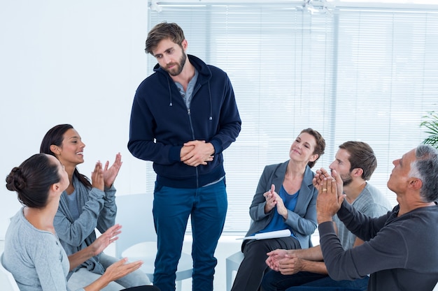 Groupe de réhabilitation applaudissant homme ravi debout