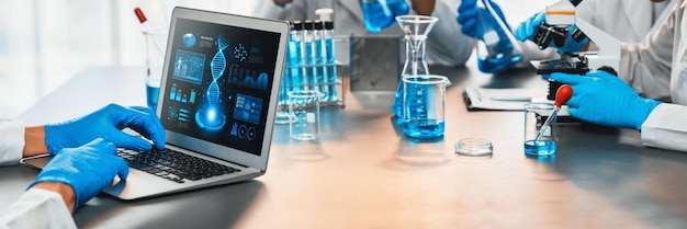 Groupe de scientifiques dédiés travaillant sur des logiciels informatiques de biotechnologie avancés pour étudier ou analyser des données sur l'ADN après avoir réalisé une percée scientifique à partir d'une expérience chimique dans un laboratoire médical néotérique
