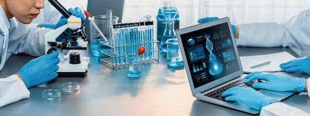 Groupe de scientifiques dédiés travaillant sur des logiciels informatiques de biotechnologie avancés pour étudier ou analyser des données sur l'ADN après avoir réalisé une percée scientifique à partir d'une expérience chimique dans un laboratoire médical néotérique