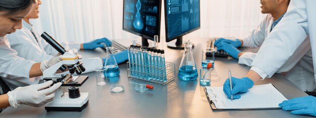 Groupe de scientifiques dédiés travaillant sur des logiciels informatiques de biotechnologie avancés pour étudier ou analyser des données sur l'ADN après avoir réalisé une percée scientifique à partir d'une expérience chimique dans un laboratoire médical néotérique