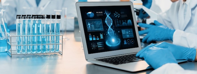 Groupe de scientifiques dédiés travaillant sur des logiciels informatiques de biotechnologie avancés pour étudier ou analyser des données sur l'ADN après avoir réalisé une percée scientifique à partir d'une expérience chimique dans un laboratoire médical néotérique