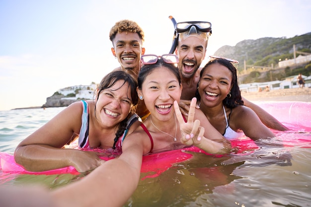 Un groupe de selfie d'amis multiraciaux joyeux en maillot de bain et lunettes de plongée