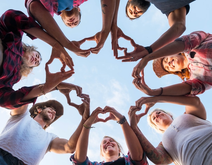 Photo groupe de sept personnes faisant ensemble un cœur avec leurs doigts et leurs mains - personnes en cricle s'amusant et jouant - vue au sol