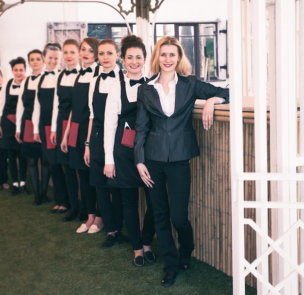 Groupe de serveurs dans un restaurant prestigieux debout dans la colonne dans le hall du restaurant