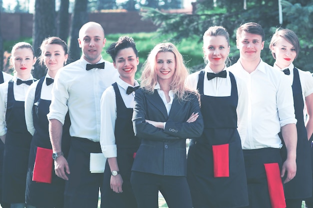 Groupe de serveurs dans les vêtements de marque sont sur la pelouse devant