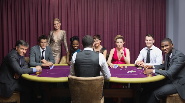 Groupe souriant assis autour d&#39;une table de poker