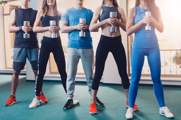 Groupe de sportifs faisant des exercices avec haltère