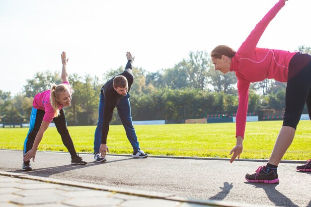 Un groupe de sportifs fait les exercices sur le stade