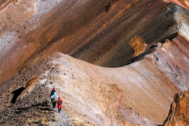 Groupe de touristes en randonnée le long de la route de montagne au sommet