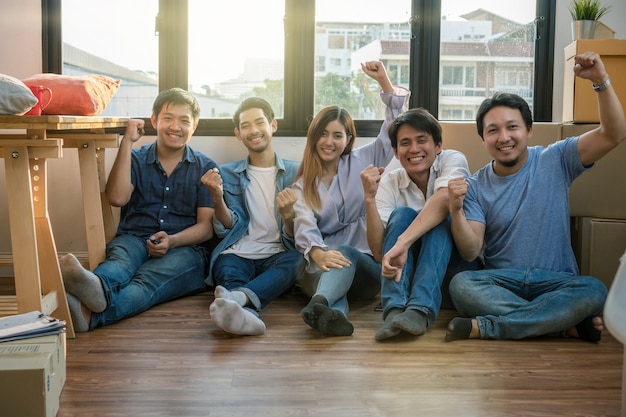 Groupe de travail d&#39;équipe asiatique sont heureux après l&#39;emballage réussi de la grande boîte en carton