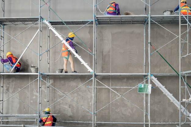 Groupe de travailleur de la construction plâtrant le réservoir d&#39;eau en béton de ciment dans la zone de construction