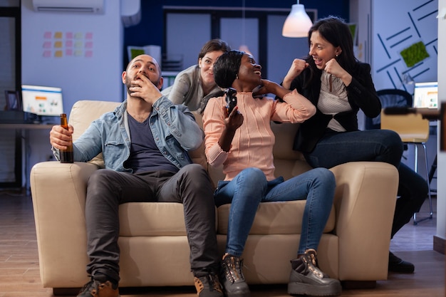 Groupe de travailleurs jouant au jeu avec des lunettes vr au bureau tout en utilisant le joystick du contrôleur. Une équipe diversifiée aime tisser des liens d'amitié lors d'une fête de célébration pour un divertissement amusant