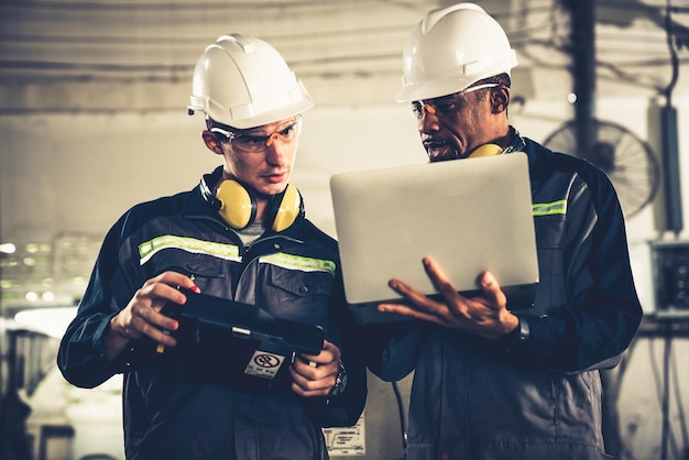 Groupe de travailleurs d'usine utilisant un équipement de machine adepte dans un atelier