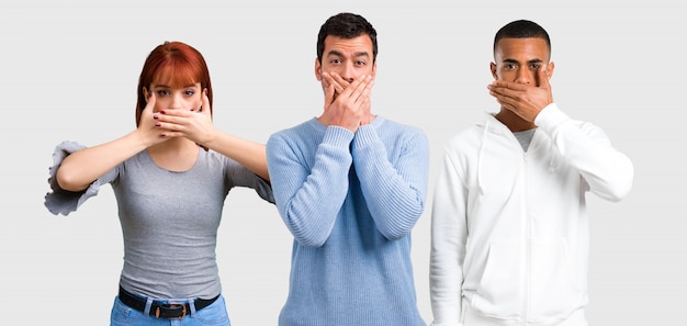 Photo groupe de trois amis couvrant la bouche avec les mains