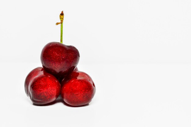 Groupe de trois cerises sur fond blanc