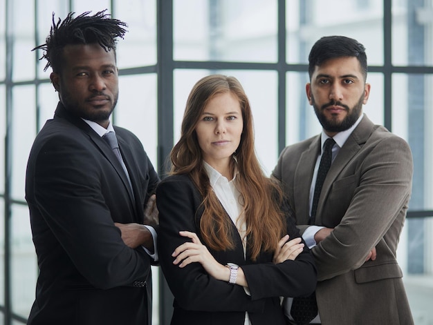 Photo un groupe de trois employés posant avec les bras croisés